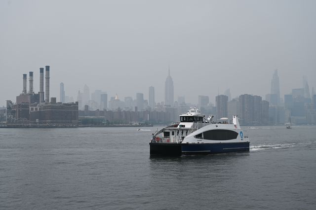 A NYC Ferry rides along the East River as the Manhattan skyline sits under a cloud of haze in New York caused by smoke from the wildfires on the West Coast.